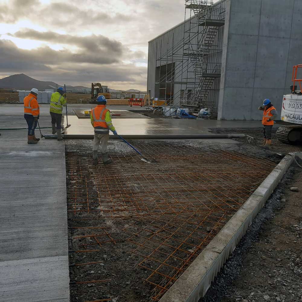 Construction site with concrete over refinforced steel bars showing